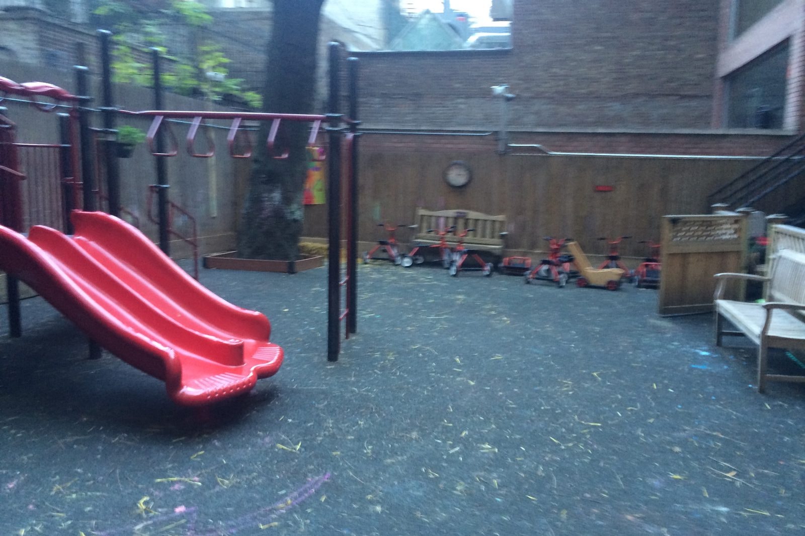 Before: close view of the old red slide and worn rubber surface.