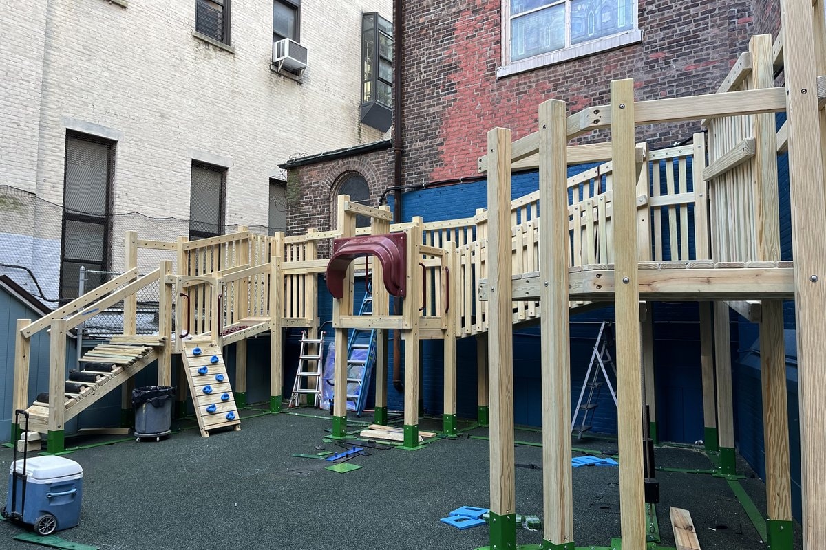 New PlayWood Plus structure going up in the courtyard — framing and decks visible.