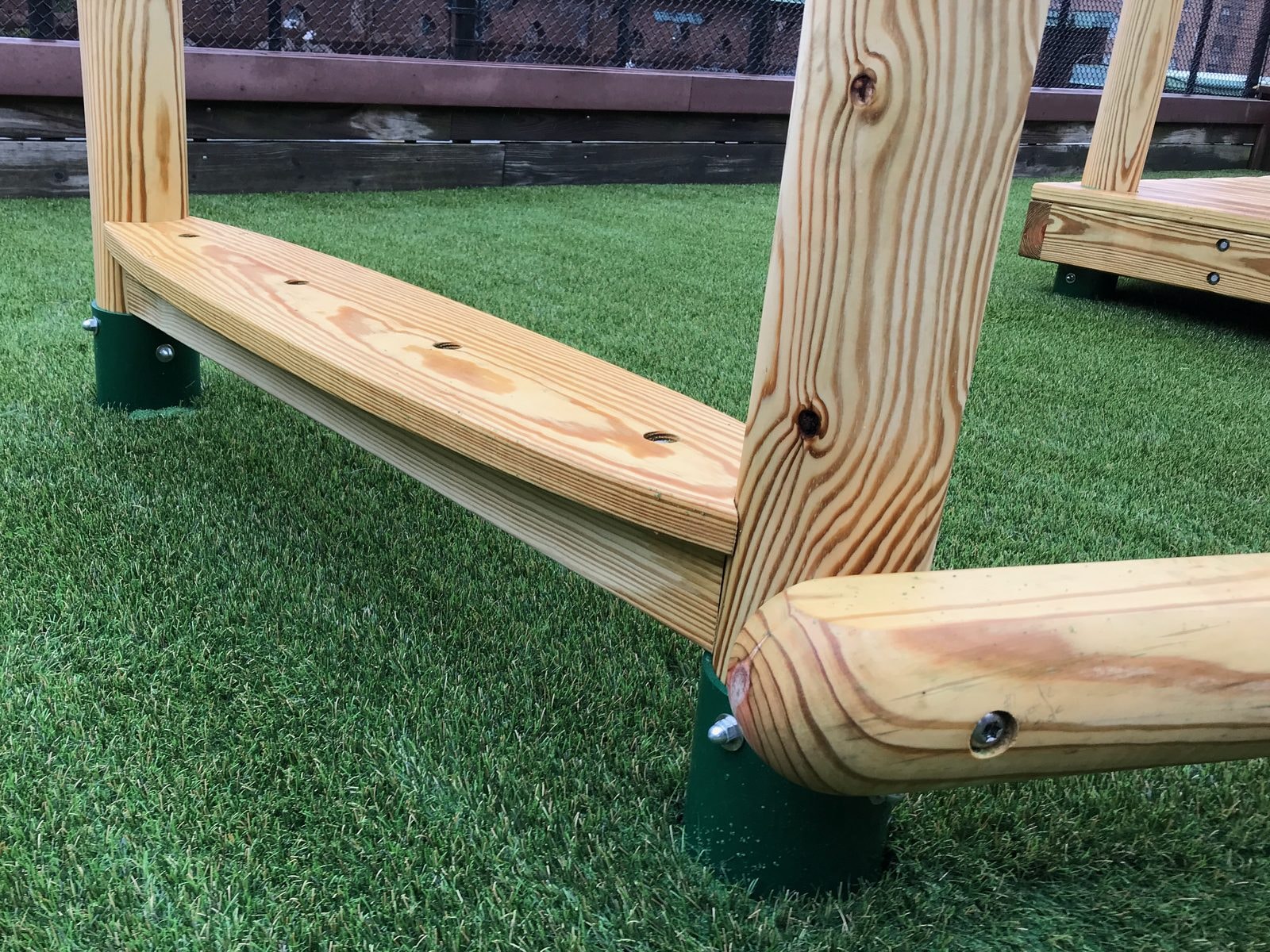 Close-up of the round-post wood launch pad on artificial turf.