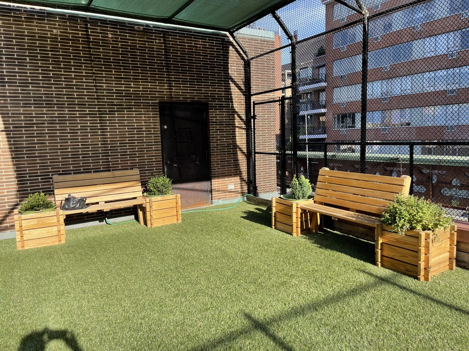 Wooden benches and planter boxes in the shaded rooftop seating area.