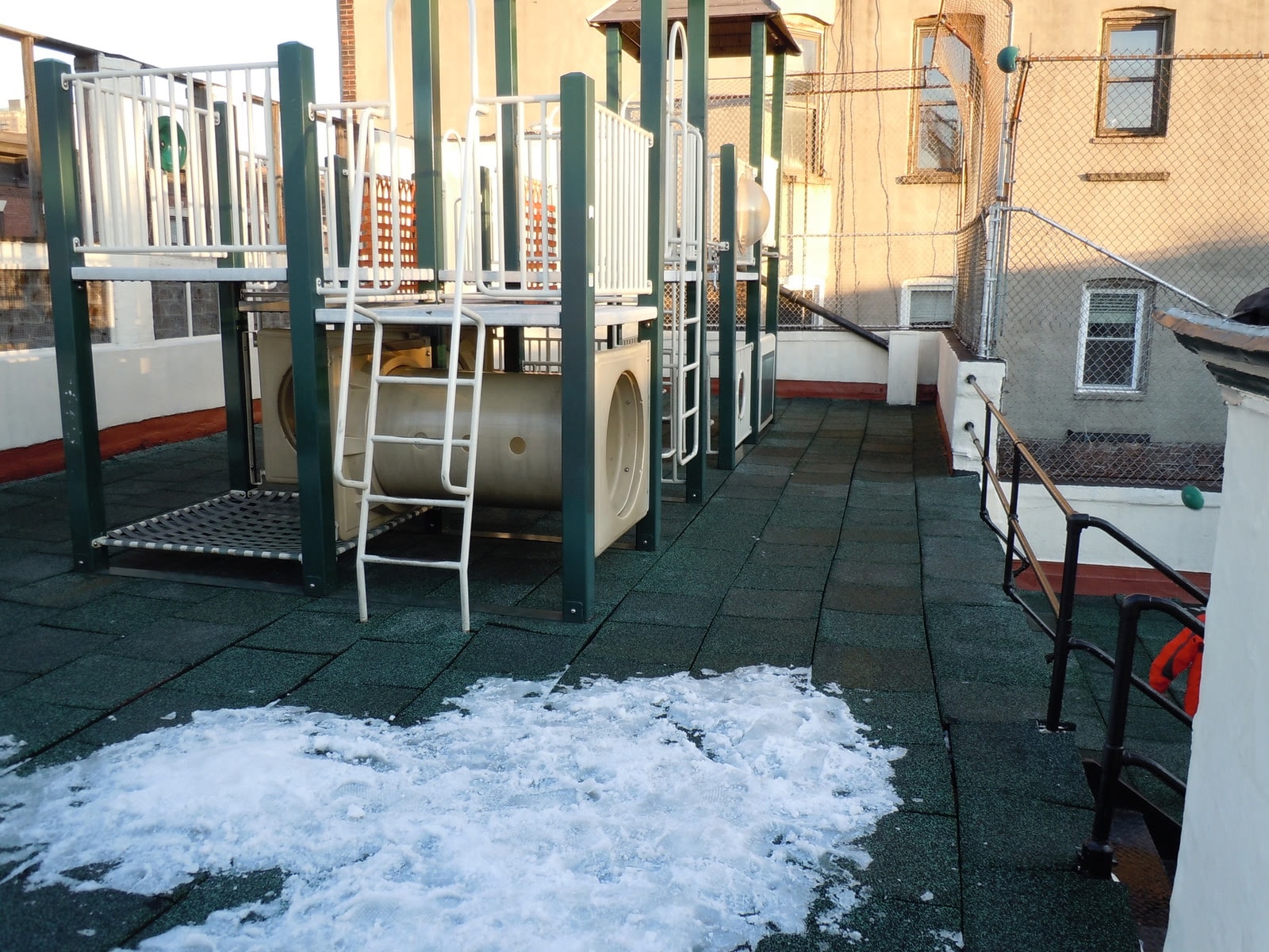 The Little Red School House rooftop before renovation — the old playground structure in winter.