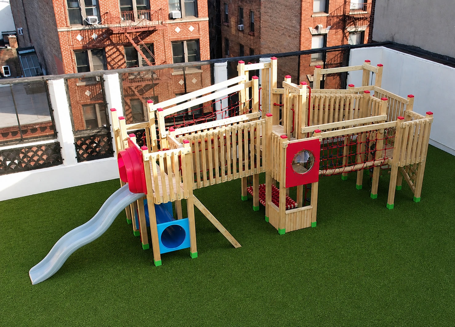 The red slide and upper deck of the Little Red School House rooftop playground.