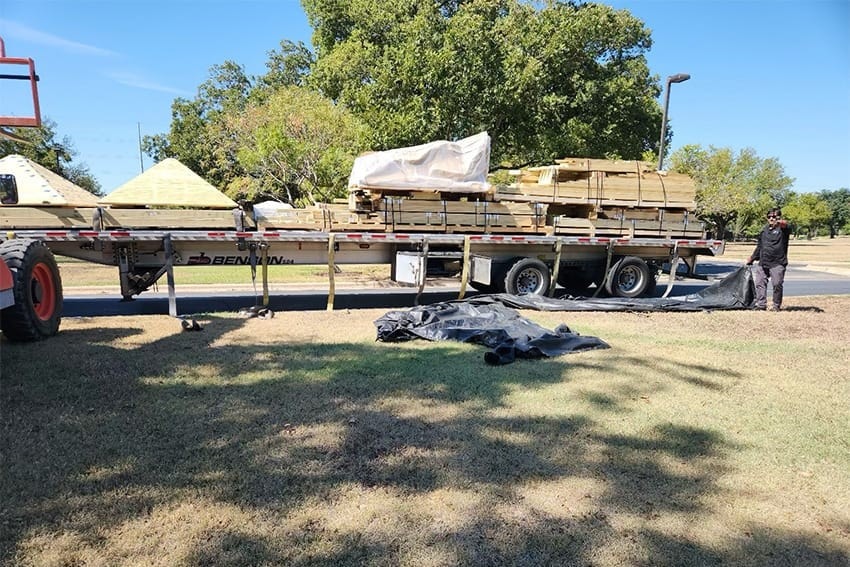 A flatbed truck delivering playscape materials