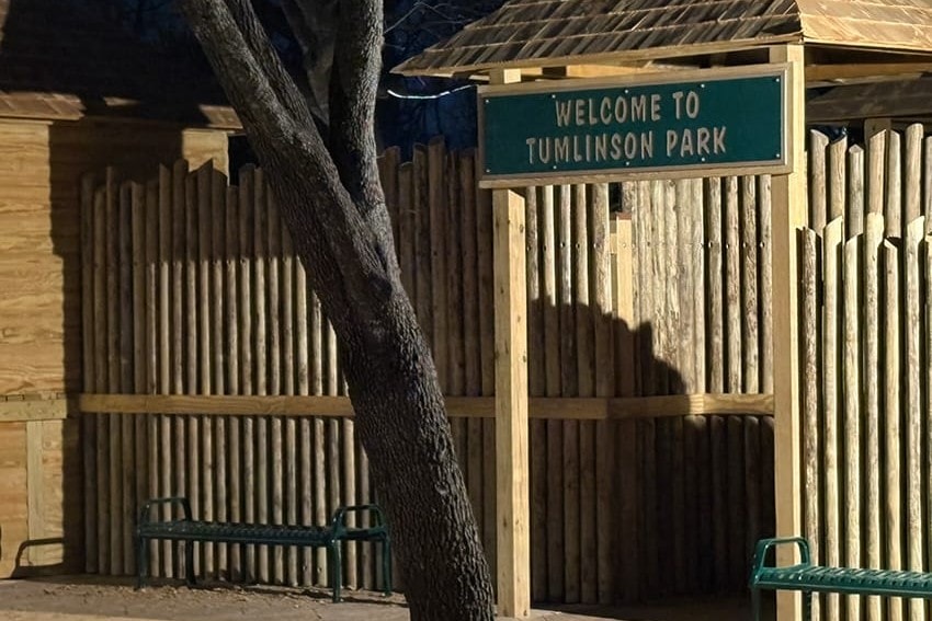 Welcome to Tumlinson Park sign on the log fort wall
