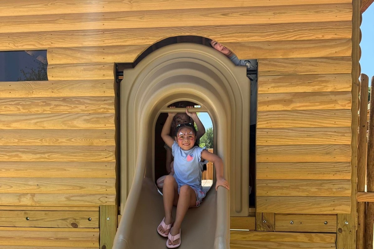 A girl at the top of a fort slide